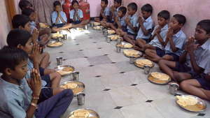 orphanchildren together praying before eating