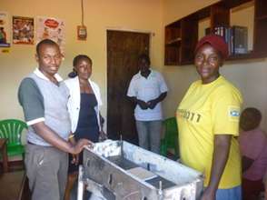 A woman Beneficiary receives Charcoal stove
