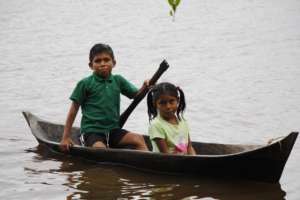 A boy brings his sister to clinic from far upriver