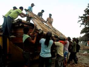 Beneficiaries helping the team unload the frames