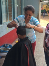 Volunteer helping in giving kids a hair cut