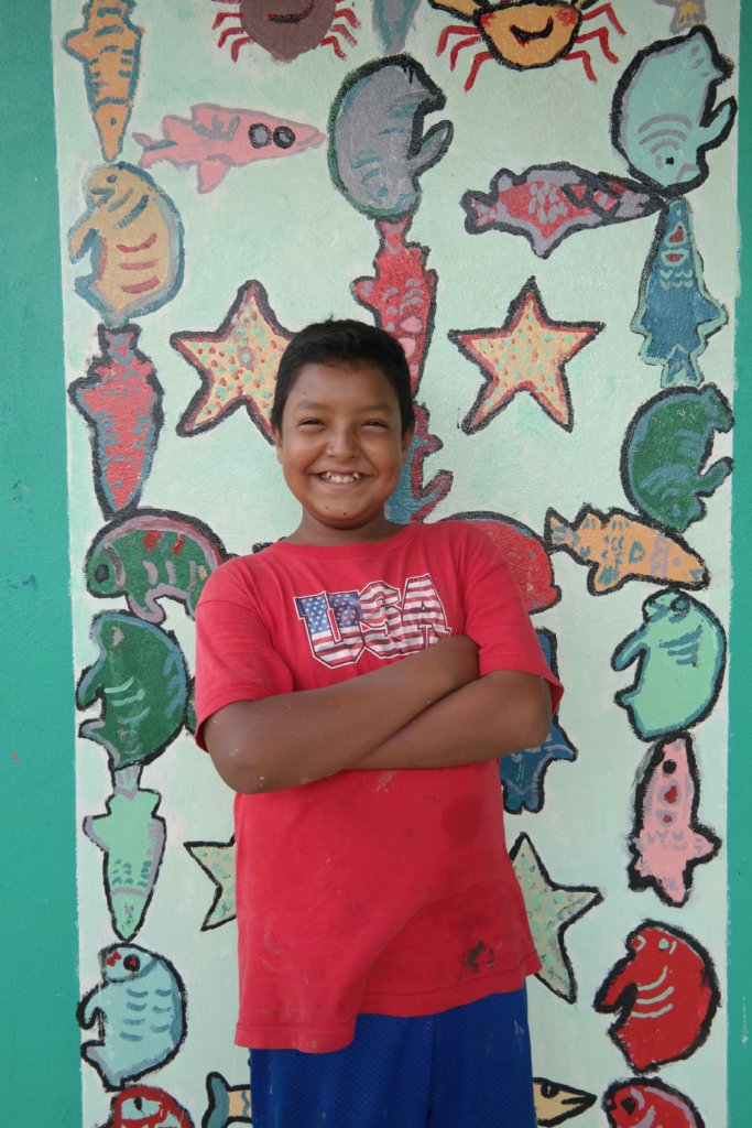 Roli proudly poses in front of one of the murals