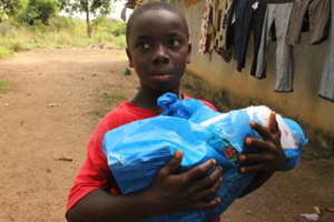 A survivor of Ebola carries a care package home