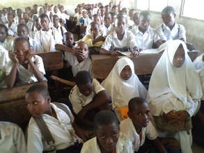 Pupils sitti inng in a crowded classroom