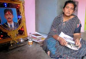 Mrs Rajalakshmi with a photo of her son Loganathan