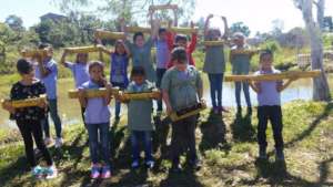 Children planting chives on bamboo