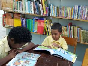 Zion reading in the Library with his classmate.