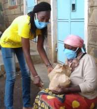 Our student giving food to an elderly granny