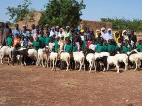 Primary school girls pose with their parents and l