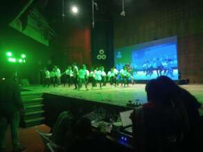 Students performing on stage for a mass audience