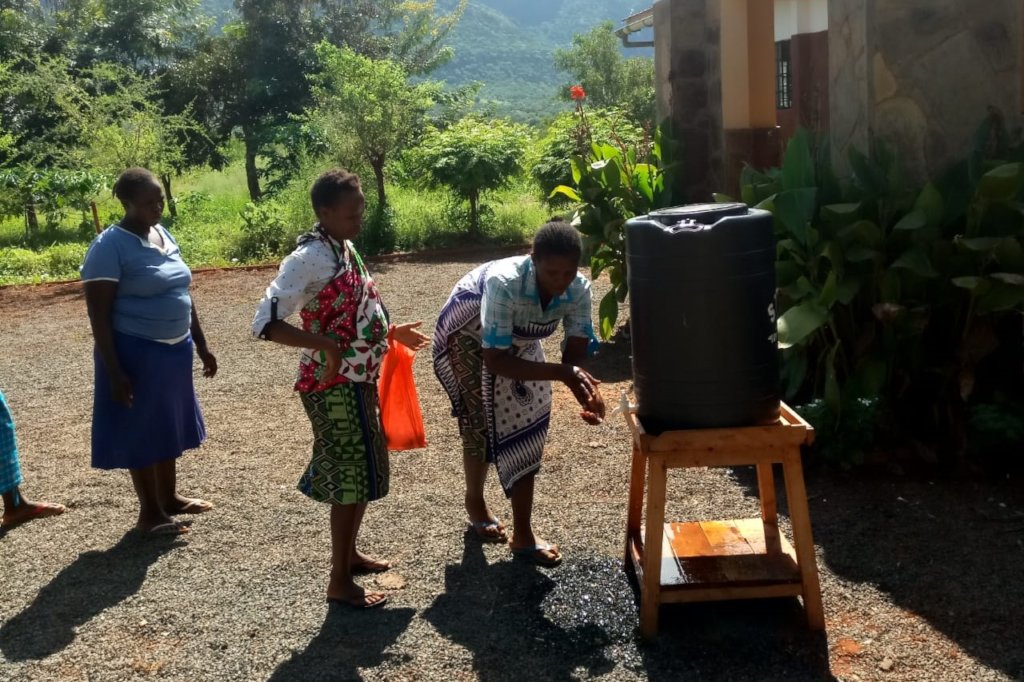 Parents washing hands before collecting food.