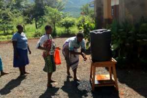 Parents washing hands before collecting food.