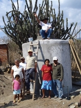 Jorge and his family proudly standing by the new rainwater stora