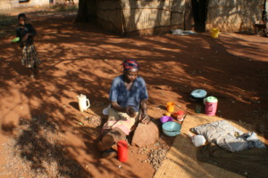 Gogo cracking marula nuts in the traditional way