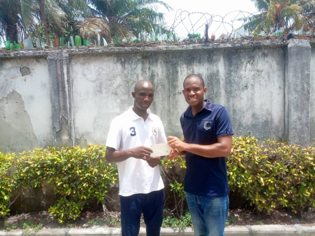 Emeke presents cheque to Chisom's dad
