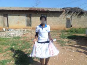 Delase carrying a bag of rice