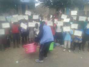 Bwana Juma giving awards to sch. children