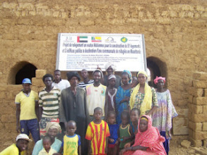 Refugee family in front of their new house