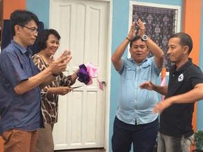 The ceremonial cutting of ribbon draws applause.