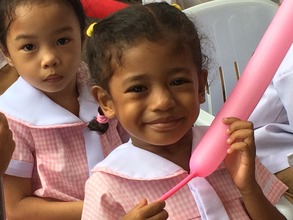 A child beams with hope w/ the new day care center