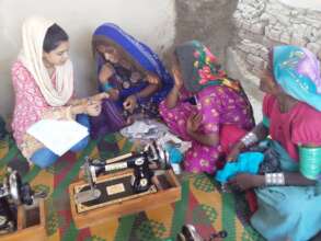Teacher testing final skills of women sewing