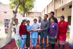 Sanjay felicitating girls from TKT in his district