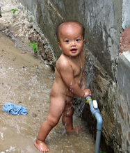 A little boy enjoying clean running water for the first time fro