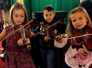 Young people playing the donated violins