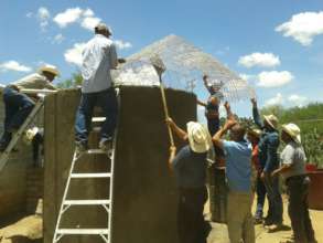 Local community members placing the cistern roof