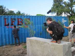 Youth painting storage container on LFBS land