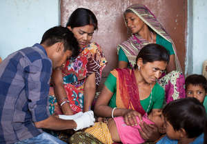 A health worker gives a child an immunization.