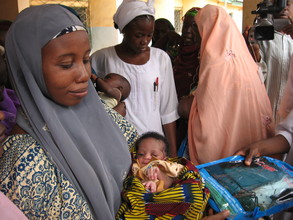A nursing mother receives insecticide treated net for her baby