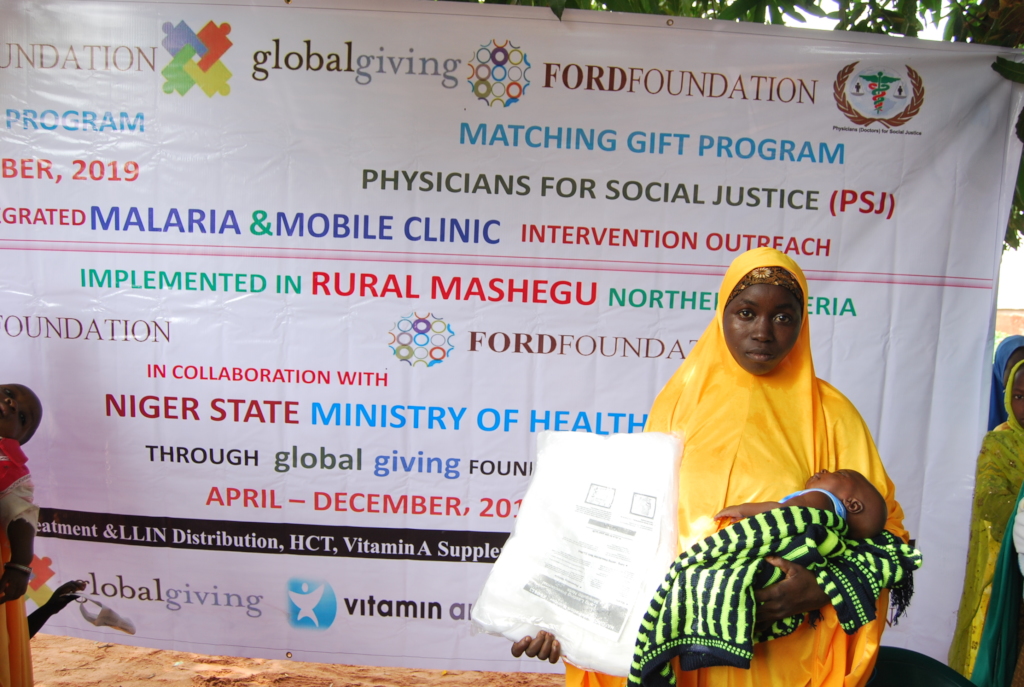 Nursing mother shows off her LLIN at Adogo village