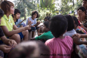 Girls discussing team work under a tree.
