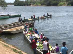 Two boats filled to the brim with produce take off