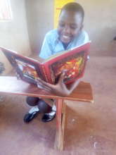 Ritah reading a donated book by a friend
