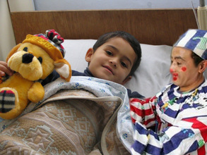 Smiling child due to the help of Clowns visit and presence.