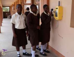 Girls using the school phone to call the guardians