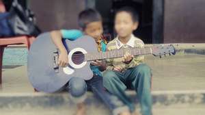 Children practicing guitar lessons