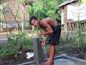 Happy kid getting water close to home