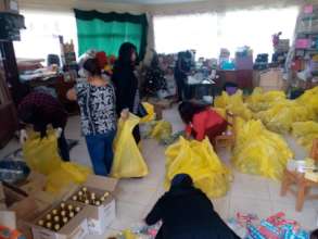 Ruth, teachers and Simeon bag up emergency food