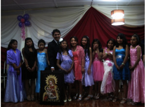 Efrain stands with& speaks to the graduating class