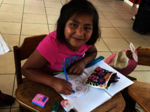 Happy to be in school she is doing her assignment