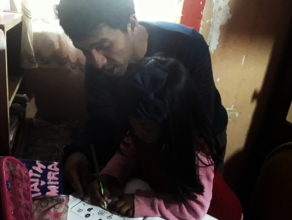 Father helps young daughter with work