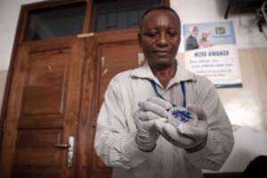 Volunteer, Rashidi helping with treatment