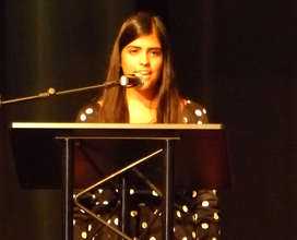 Lina describing the goals of the benefit concert