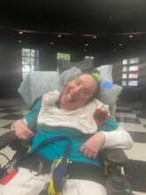 Cathy wearing a Memorial red poppy made at SPARC!