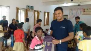 A volunteer gifting the school kit