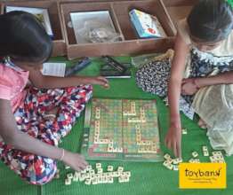 Children practice word making with Scrabble