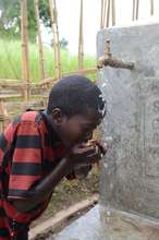 A boy washes his face with a CLEAN water supply